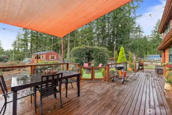Deck with cover overlooking the peaceful grounds, offering a spacious outdoor setting ideal for dining, relaxing, and enjoying the surrounding landscape.