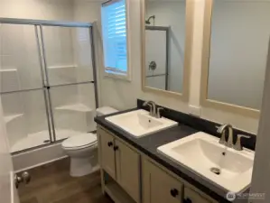 Primary bathroom with double vanities and walk in shower.