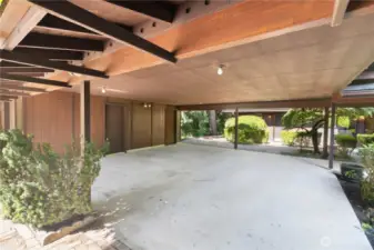 Oversized two-car carport with 2 attached shops room for vehicles, gear, or covered workspace.