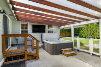back patio, perfect for entertaining and BBQ cooking, hanging out in theGorgeous covered  big jacuzzi and watching the game on the exterior mounted tv. Also custom fencing for kis playing or pets