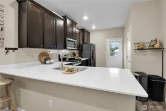 Quartz counters with eating space.  To the right is a nice pantry.