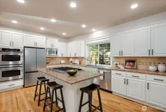 A Chef’s Kitchen: Large kitchen island, granite countertops and updated cabinetry.