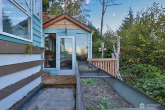 Raised flowers beds along side the shed and greenhouse.
