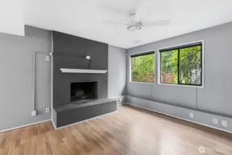 Lower-level living area with elegant wood fireplace and oversized picture windows.