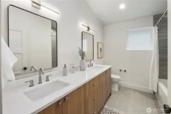 Guest bathroom includes double vanity with plenty of storage and cool light fixtures