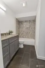 The full bath on the second floor has been remodeled with new tile flooring, tile shower surround, new cabinetry, sink, light fixtures, etc...