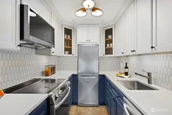 The kitchen is beautifully refreshed with quartz counters, tile backsplash, generous cabinets, new stainless appliances, induction range and deep farm sink.