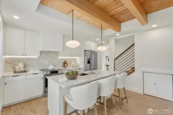 Custom-designed kitchen with large island, full height natural stone backsplash, and under-cabinet lighting.  Microwave and dishwasher in island.  Tons of natural light make this space perfect for relaxing or entertaining.