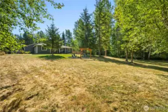 View from the back fenced area towards the back of the home. There is a gate to the left of the home for access to the back yard.