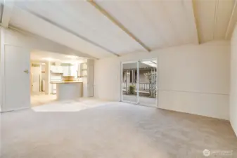 This view highlights the open floor plan—ideal for entertaining or everyday living. Sliding glass doors lead directly to the covered carport for easy access.