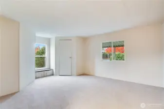 A bright second bedroom features a walk-in closet and a charming built-in window seat with extra storage.