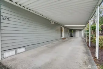 The extended carport provides space for multiple vehicles and keeps you dry from car to home. At the far end is an insulated storage room.