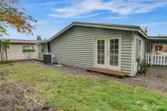 French doors from the primary suite open to a fully fenced backyard with endless possibilities for gardening or outdoor living.