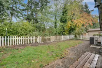 The yard backs up to lush greenery, adding privacy and a beautiful natural backdrop.