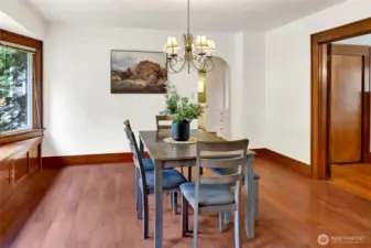 The dining room is filled with natural light from a charming bay window, complete with built-in storage below. Spacious enough to gather a crowd, it's the perfect spot for hosting memorable meals.