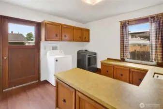 This versatile laundry room not only offers exterior access but was also used as a sewing room, complete with ample cabinets and counter space.