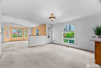 Dining room view towards living room with arched window.