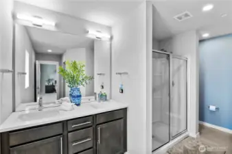 Primary Bath features double vanity, large shower, & hidden comode.