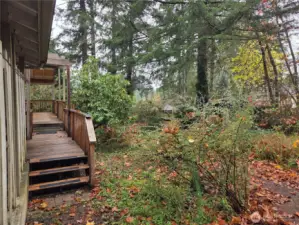 steps onto back deck. Wood pile located under a covered back deck area leading toward kitchen and living room. Plus back entry into garage.