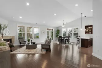 The light-filled and airy great room features vaulted ceilings, a gas fireplace, recessed lighting and French doors out to the covered deck.