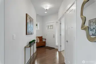 The hallway looking towards the entry from the great room. The door on the right is a closet, the open double doors lead to the den.
