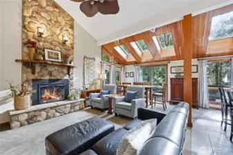 Straight down the entry hall you will enter the open concept living/dining/kitchen spaces complete with vaulted ceilings, wood-wrapped columns/windows/skylights, a river rock electric fireplace, and so much more!