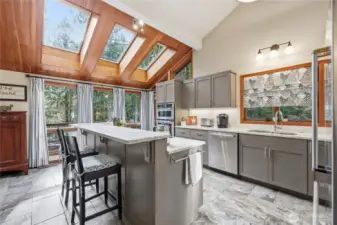 Another view of the kitchen looking out towards the deck. Note the eating bar as well as the amazing skylights.