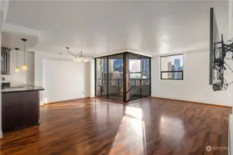 From hallway view of living room and dining area leading to balcony.