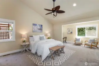 Retreat to the serene main-floor primary suite with vaulted ceilings, soft natural light, and tranquil views.