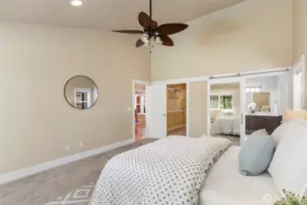 Wake up to peaceful garden views in this spacious primary suite with vaulted ceilings.