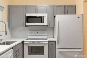 Kitchen with beautiful countertops, tile backsplash, and shaker cabinets.