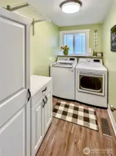 Nice sized laundry with laminate flooring and window.