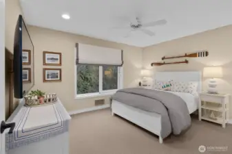 The second en-suite bedroom overlooks the lush hillside, offering a serene retreat for relaxation.