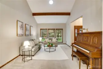 Bright and welcoming living room anchored by a large picture window and wood beam detail, perfect for morning coffee or evening conversations.