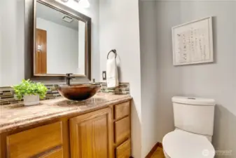 Updated powder room with vessel sink, granite-style counter, and framed mirror—an easy, stylish stop for guests just off the main living areas.