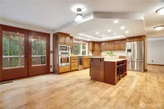 Large eat-in kitchen with center island, ovens, microwave & stainless fridge, and French doors that open to the deck—ideal for everyday living and big holiday gatherings.