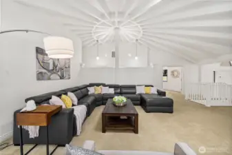 The main-level living room is highlighted by a graceful 14-foot circular ceiling with exposed beams