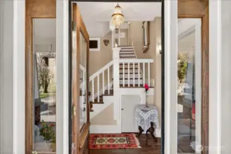 Step through the intricate front entry into a beautiful piece of history. The grand foyer of this 1890 home immediately welcomes you with its stunning original grand staircase, glowing crystal chandelier, and rich wood floors. The care of details, including the sidelights framing the view back to the private drive, are a testament to this home having just four owners in 136 years. It is a beautiful, welcoming first impression of a true Stanwood legacy.