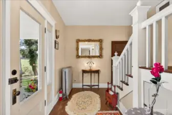 Inside you can immediately feel the history. The entryway welcomes you with hardwood floors and that classic 1890 grandeur. The elegant grand staircase on the right is a perfect match for the vintage details, like the white cast-iron radiator. With light streaming through the glass front door, this foyer offers warmth and charming introduction to this remarkable estate.