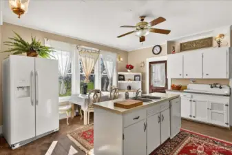 The kitchen shows why that breakfast nook is the best seat in the house. You’re looking right out over the fields and the privacy of the property while you have your morning coffee. It keeps all that 1890 charm with the vintage high-back sink and original cabinets, but has the island space you actually need. It’s just a simple, sunny spot that feels like home.
