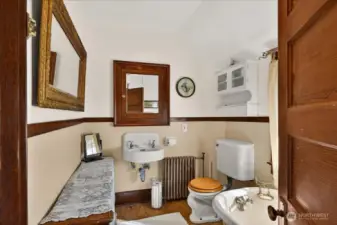 The top floor bathroom is full of charm, especially with that classic clawfoot tub. It has a great vintage feel with the wall-mounted sink, original radiator, and the rich wood trim that ties in with the rest of the house. The sloped ceilings and hardwood floors make the space feel bright and cozy—a perfect, quiet spot to unwind.