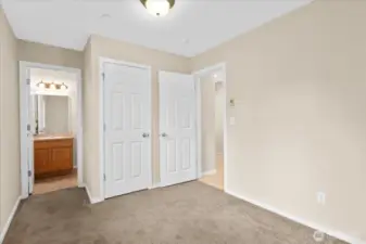 Bedroom with carpeted flooring, and access to a private bathroom.