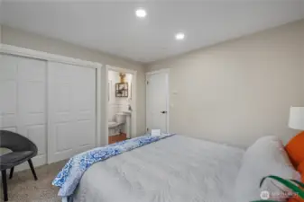 Another view of the primary bedroom with large closet and bathroom with walk in shower.