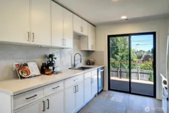 Spacious kitchen opens to the deck overlooking the backyard for easy access when grilling and entertaining.