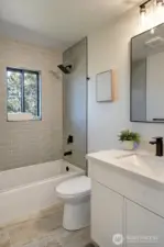 Main floor full bath boasts custom tiles and stylish fixtures.