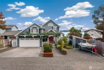 Planter lined walkway to a pergola draped with mature kiwi vines. Programmable Smart drip system which automatically adapts to the weather. Plenty of parking space with room for an RV.