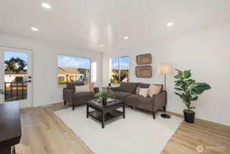 Corner view of the living area showcasing multiple windows that bring in abundant natural light and neighborhood views.