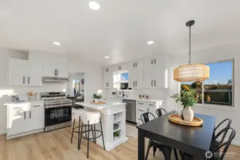 Open-concept kitchen and dining area with center island seating, coordinated lighting, and seamless connection to the main living space.
