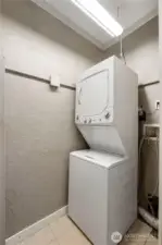 A conveniently located laundry closet sits within the bathroom, making everyday routines simple and efficient. The stacked washer and dryer are tucked neatly out of sight, offering practical convenience without sacrificing usable space.