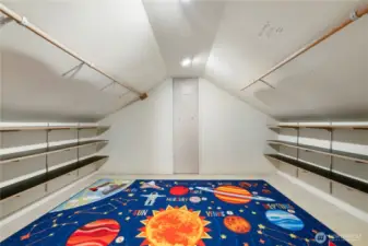 This expansive upstairs loft offers a surprising amount of usable space, with built-in shelving along both sides that makes it ideal for organized storage, seasonal items, or hobby supplies. The pitched ceiling creates a cozy, tucked-away feel while still allowing for generous floor space down the center. It’s a practical solution for anyone who values room to spread out and keep things neatly out of sight.